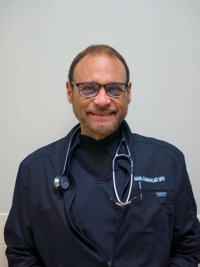 a man wearing glasses and smiling at the camera